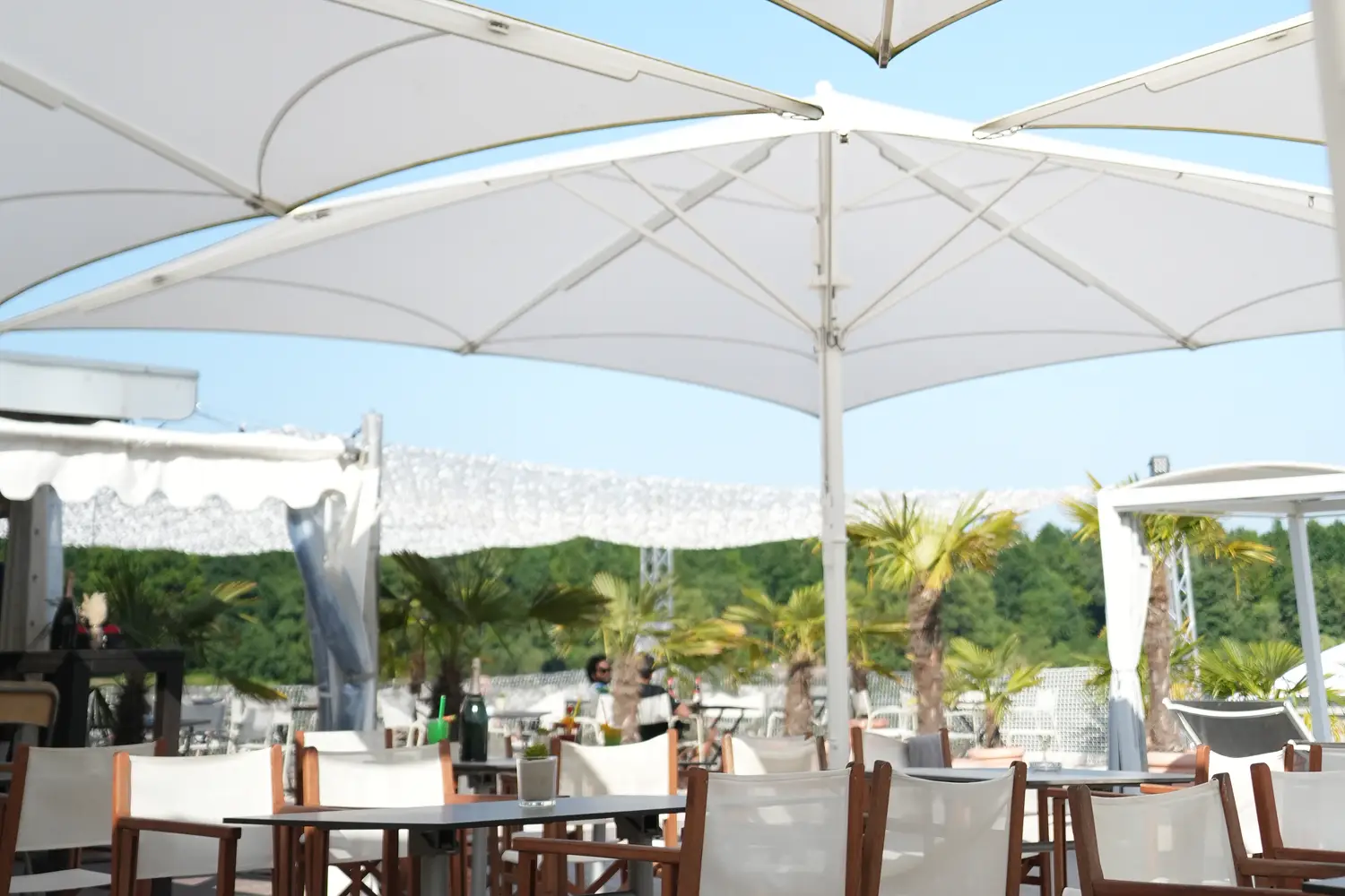 Seeterrasse am Otto-Maigler-See mit weißen Sonnenschirmen