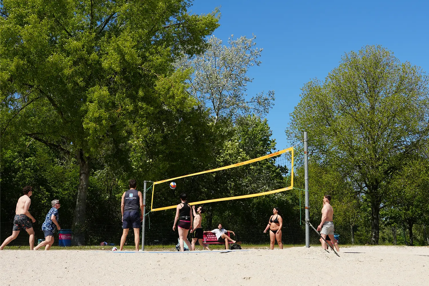 Gruppe spielt Beachvolleyball auf dem Sandfeld am Otto-Maigler-See