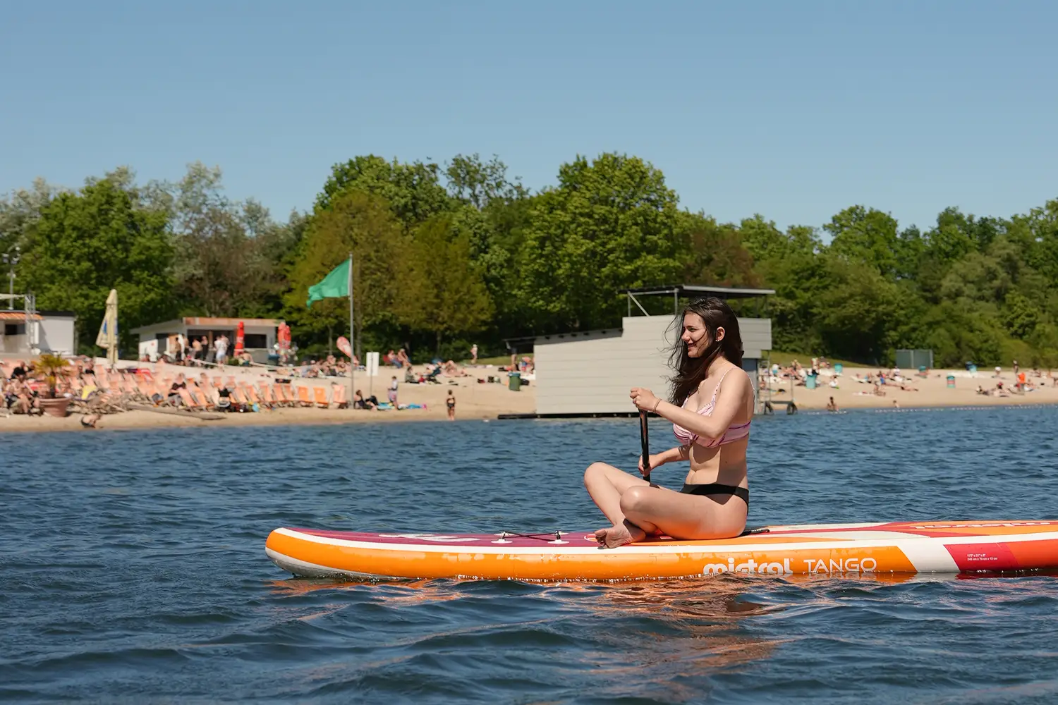 Frau sitzt auf einem SUP-Board auf dem Otto-Maigler-See