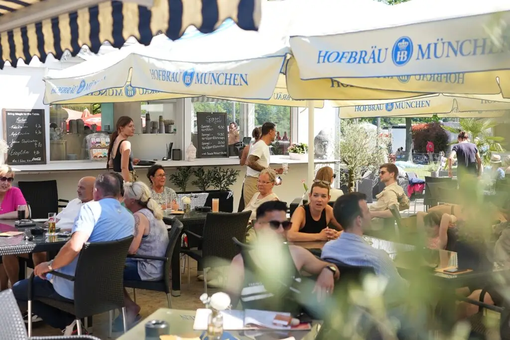 Gäste sitzen auf der Seeterrasse am Otto-Maigler-See